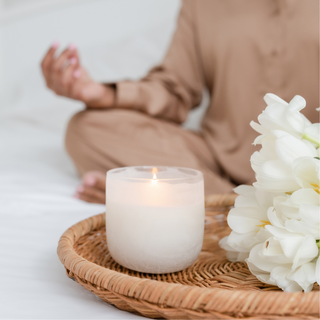 Person meditating with a lit candle Easter bunny ornament on a table | Vancouver Gift Baskets for Feeling Better and Get Well