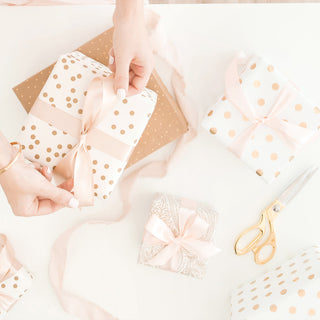 Person wrapping gifts in paper Easter bunny ornament on a table | Vancouver Gift Baskets for Birthdays
