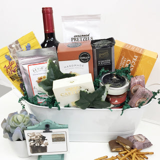 White basket with wine and food items Easter bunny ornament on a table | Vancouver Gift Baskets Best Sellers