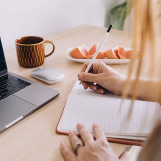 Woman writing in a notepad Easter bunny ornament on a table | Vancouver Gift Baskets for Employee Appreciation
