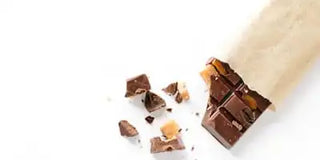 Chocolate pieces and a chocolate bar on a white background