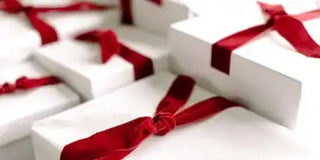 White gift boxes with red ribbons arranged in a row.
