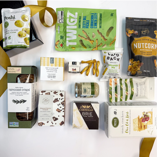 Assorted snacks and cheeses displayed on a white surface with decorative ribbons.
