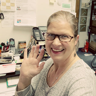 Carole MacFadden, owner of vancouvergiftbaskets.com, waving from her office