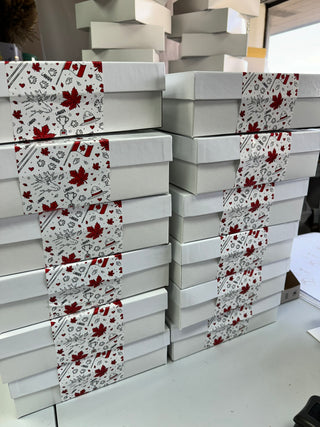 Stacks of white boxes with red and black patterns on a white surface.