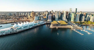 Vancouver skyline with waterfront and buildings, including a large white building and a dock.