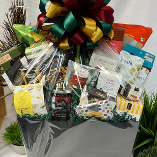 Gift basket with various items including snacks and a coffee can, tied with a colorful bow.